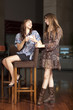 Two young women drinking coffee at a bar