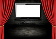 Red Stage Theater Drapes and LCD screen in a dark room