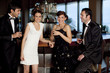 Two couples at bar drinking and flirting
