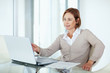 Photo: Confident mature businesswoman looking at laptop Confident mature businesswoman looking at laptop