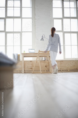 Foto: Woman walks across loft apartment Woman walks across loft apartment