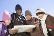 Group of friends stand looking at map together
