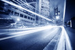 Fast moving cars lights blurred over modern city background