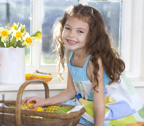 Photo: Happy girl with basket of wooden Easter eggs Happy girl with basket of wooden Easter eggs