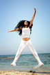 Beautiful happy woman exercising on the beach.