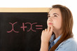 Thoughtful Looking Female Student Standing Next To Blackboard Thoughtful Looking Female Student Standing Next To Blackboard