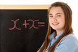 Female Student Standing Next To Blackboard Female Student Standing Next To Blackboard