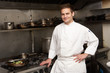 Male Chef Standing Next To Cooker In Restaurant Kitchen
