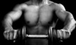 Powerful muscular man holding a dumbbell