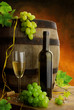 Still life with white wine, fresh grapevine and old cask