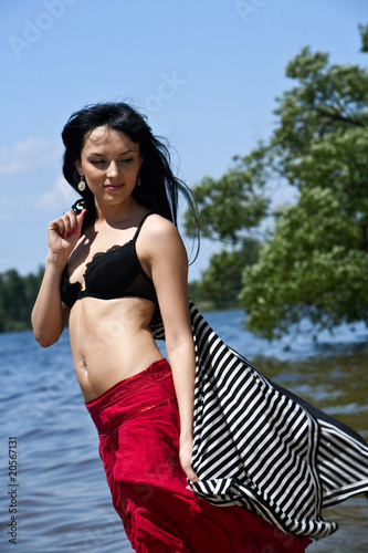 Photo: Beautiful young woman dreaming on the beach Beautiful young woman dreaming on the beach