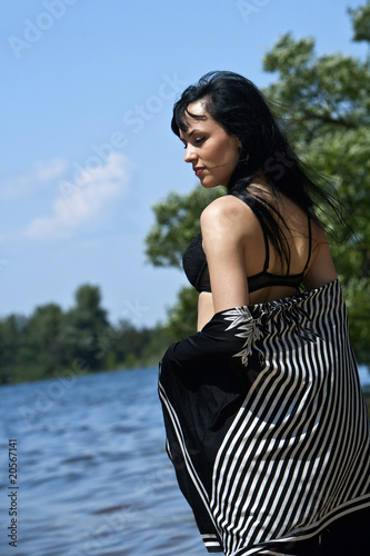 Photo: Beautiful young woman dreaming on the beach Beautiful young woman dreaming on the beach