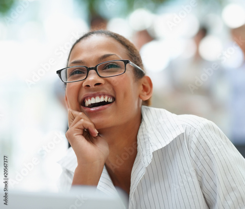 Photo: Young business woman laughing over a thought Young business woman laughing over a thought