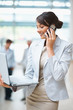 Young business woman talking on cellphone with a laptop