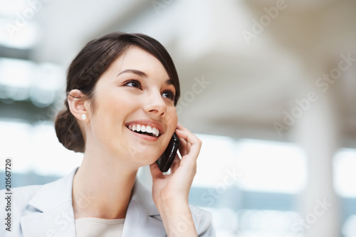 Photo: Beautiful lady using cellphone while looking at copyspace Beautiful lady using cellphone while looking at copyspace