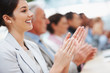 Happy business woman with colleagues applauding