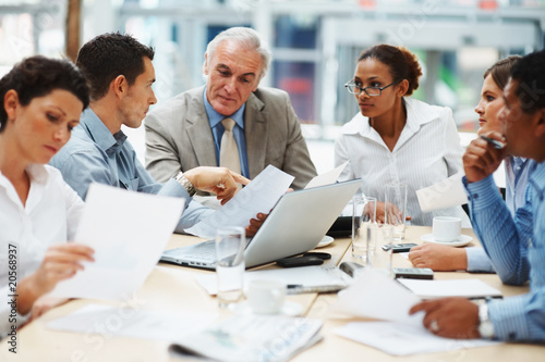 Photo: Business people discussing work on laptop at a meeting Business people discussing work on laptop at a meeting