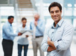 Young executive standing with team discussing at the back Young executive standing with team discussing at the back