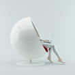The girl sitting in a chair with a laptop on his lap.