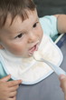 Young woman's hand feeding baby boy