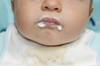 Closeup of baby boy's mouth with food around it