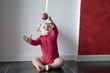 Baby boy sitting on floor reaching for Christmas ball