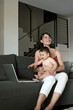 Young woman with baby at laptop computer