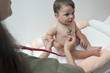 Female hand holding stethoscope to baby boy
