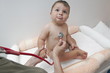 Female hand holding stethoscope to baby boy