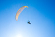 Yellow paraglider in serene cloudless blue sky