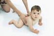 Naked baby boy held by young woman's hands