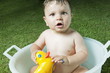 Baby boy taking bath in tub in garden