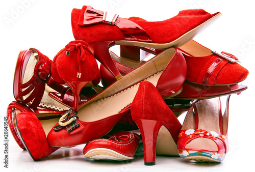 Photo: Pile of female red shoes isolated on white background Pile of female red shoes isolated on white background