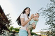 Young woman dancing in garden with baby boy