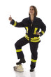 Junge Feuerwehrfrau in Uniform, Daumen hoch