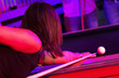 Young adults at a nightclub playing pool