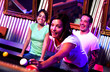 Young adults at a nightclub playing pool