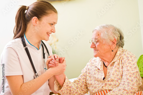 Photo: A caring doctor and an elderly sick woman holding hands A caring doctor and an elderly sick woman holding hands