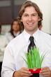 Business man holding a plant