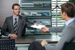 Car salesperson giving catalog to businessman