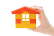 Hand and toy house isolated on white background