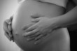Mid section closeup of a pregnant woman holding her tummy