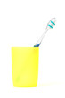 toothbrush in a yellow cup isolated on white background