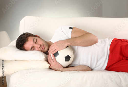 Photo: junger mann schläft mit seinem fussball sieger junger mann schläft mit seinem fussball sieger