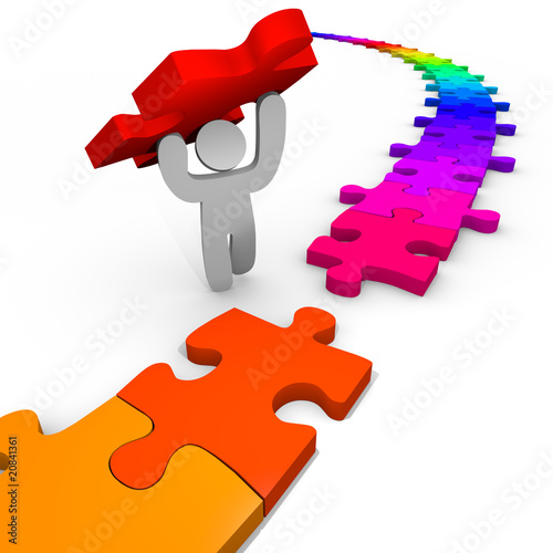 Illustration: Puzzle - Person Lifts Piece Into Place Puzzle - Person Lifts Piece Into Place