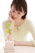 観葉植物を見つめる女性