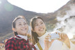 温泉地で記念撮影をする女性