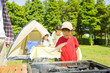 バーベキューの炭に火をおこそうと団扇で扇ぐ男の子