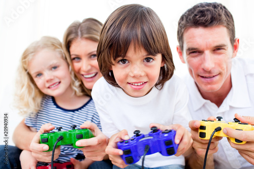 Photo: Lively family playing video game Lively family playing video game