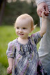 Little smiling baby holding father's hand